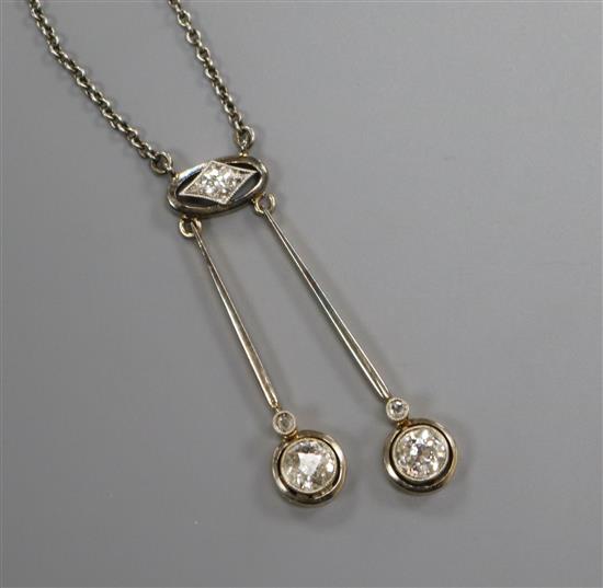 A 1920s/1930s white and yellow metal, three stone diamond set double drop pendant necklace, pendant section 34mm.,